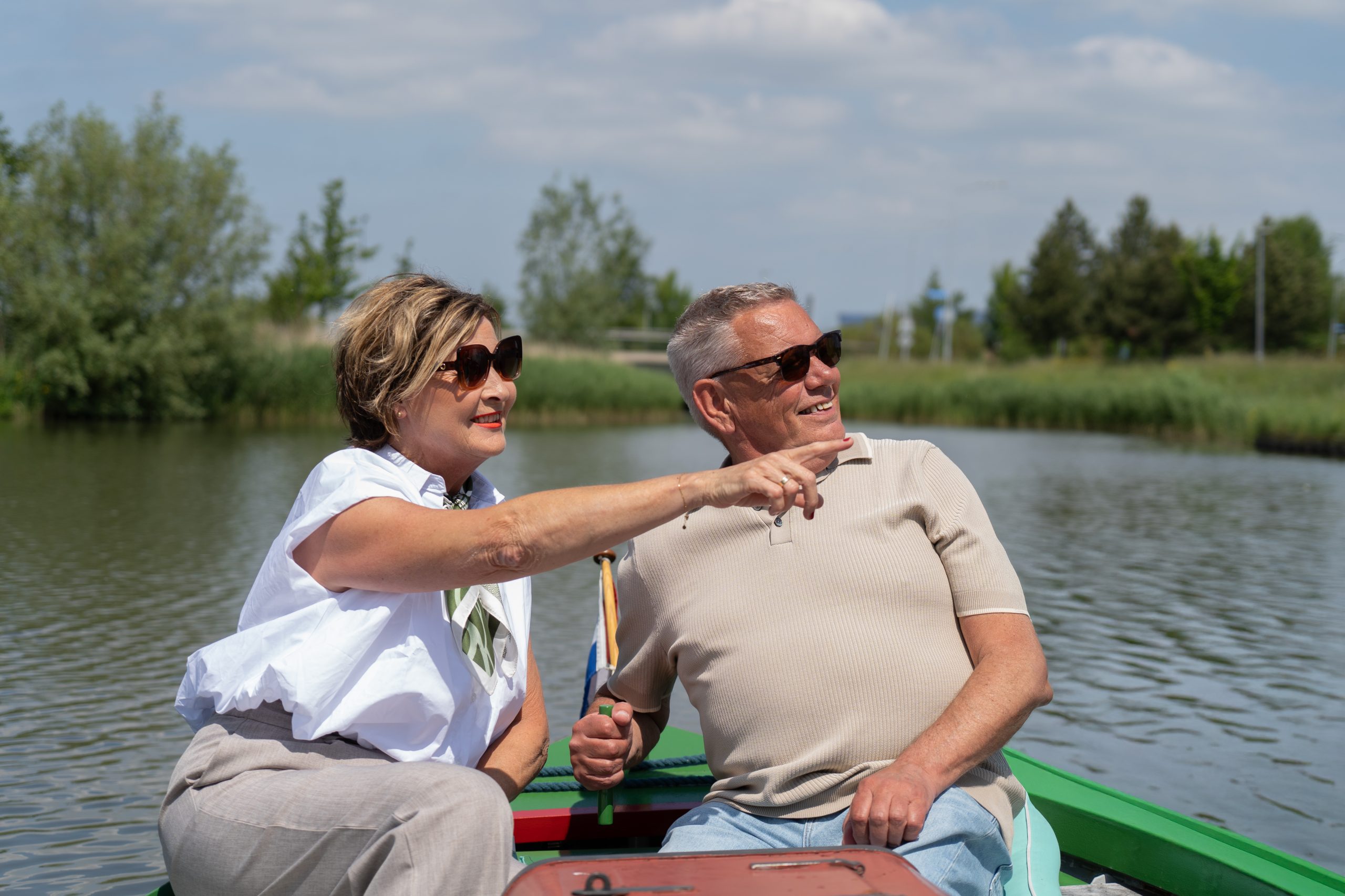 Twee senioren varen in een koolschuit.